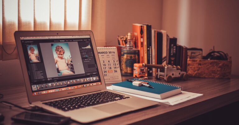 Warm-toned home office desk with a laptop, notebook, and books. Perfect for freelancers.